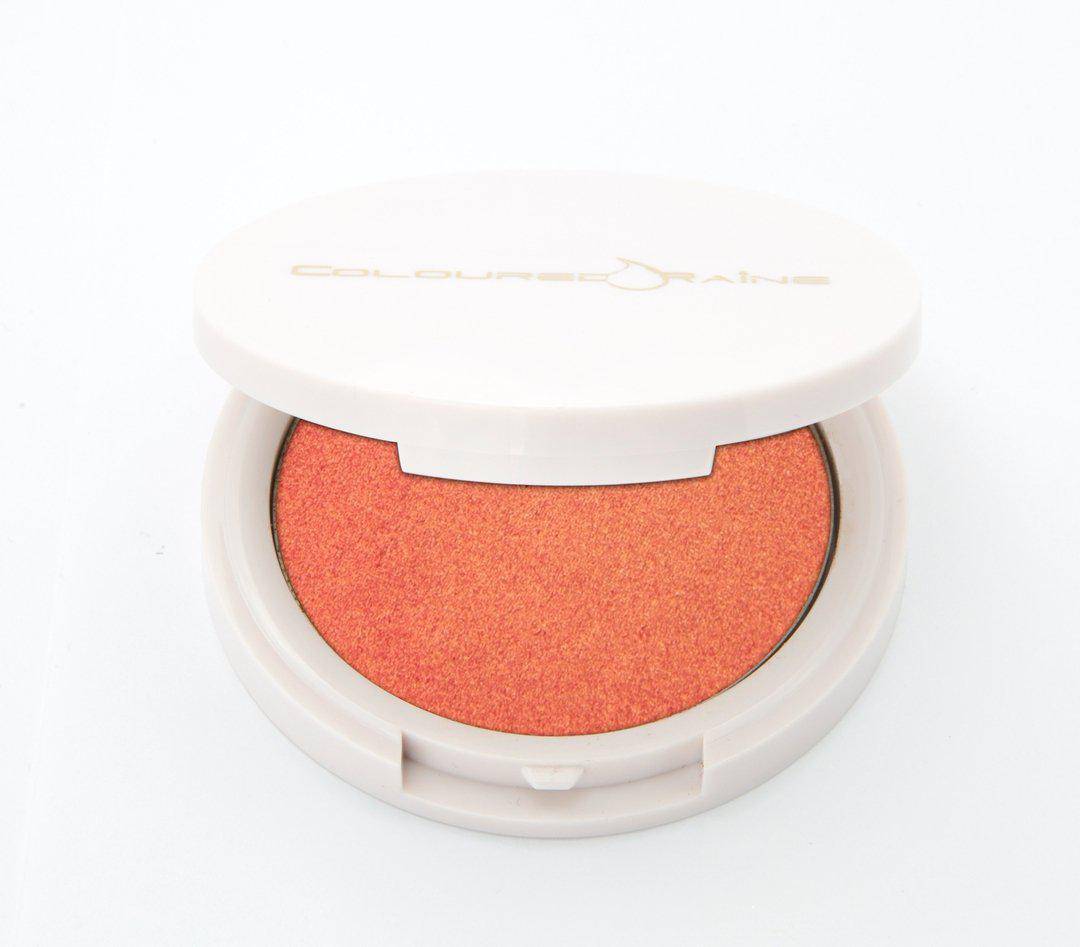 Peach highlighter with gold undertones, in a half-open container